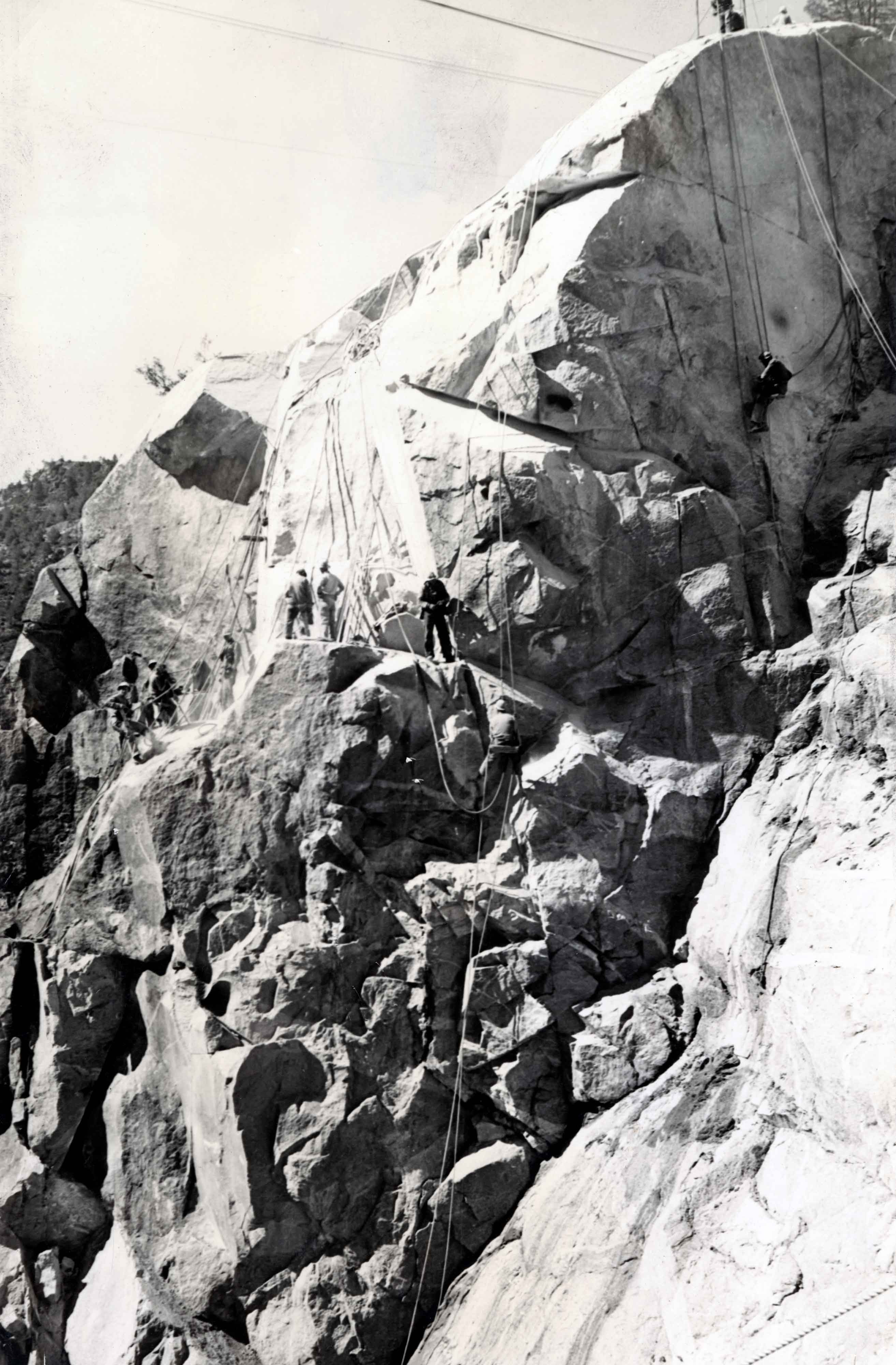 Scalers on the north abutment of the dam drilling and blasting for a broader foundation for new cement. Courtesy of San Francisco Public Library.